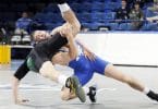 Two collegiate wrestlers, one upended, asics wrestling shoes