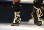 Close up action shot of wrestler walking forward with laced up boots.