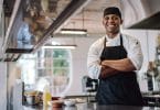 Chef in his kitchen with crossed arms and smiling
