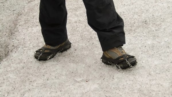 Hiking on ice with heavy duty cleats strapped on to boots