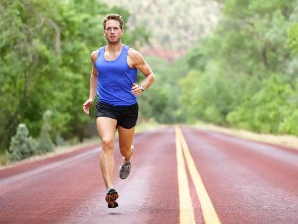 Empty road with man training in blue tank top.