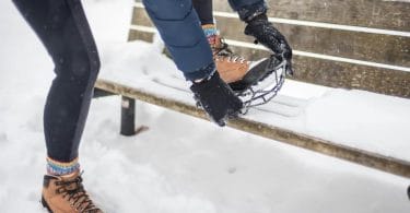 Woman putting on nano spike best ice cleats for traction in the snow