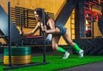 Woman pushing sled with 100kg weights using some of the best CrossFit shoes for traction.